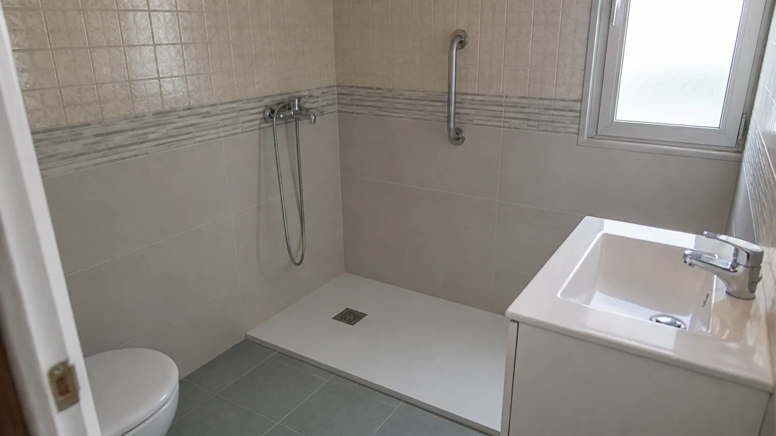 Plato de ducha extraplano blanco instalado en el hueco de una antigua bañera de un piso